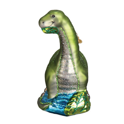 Decorative glass ornament of a green dinosaur on a white background