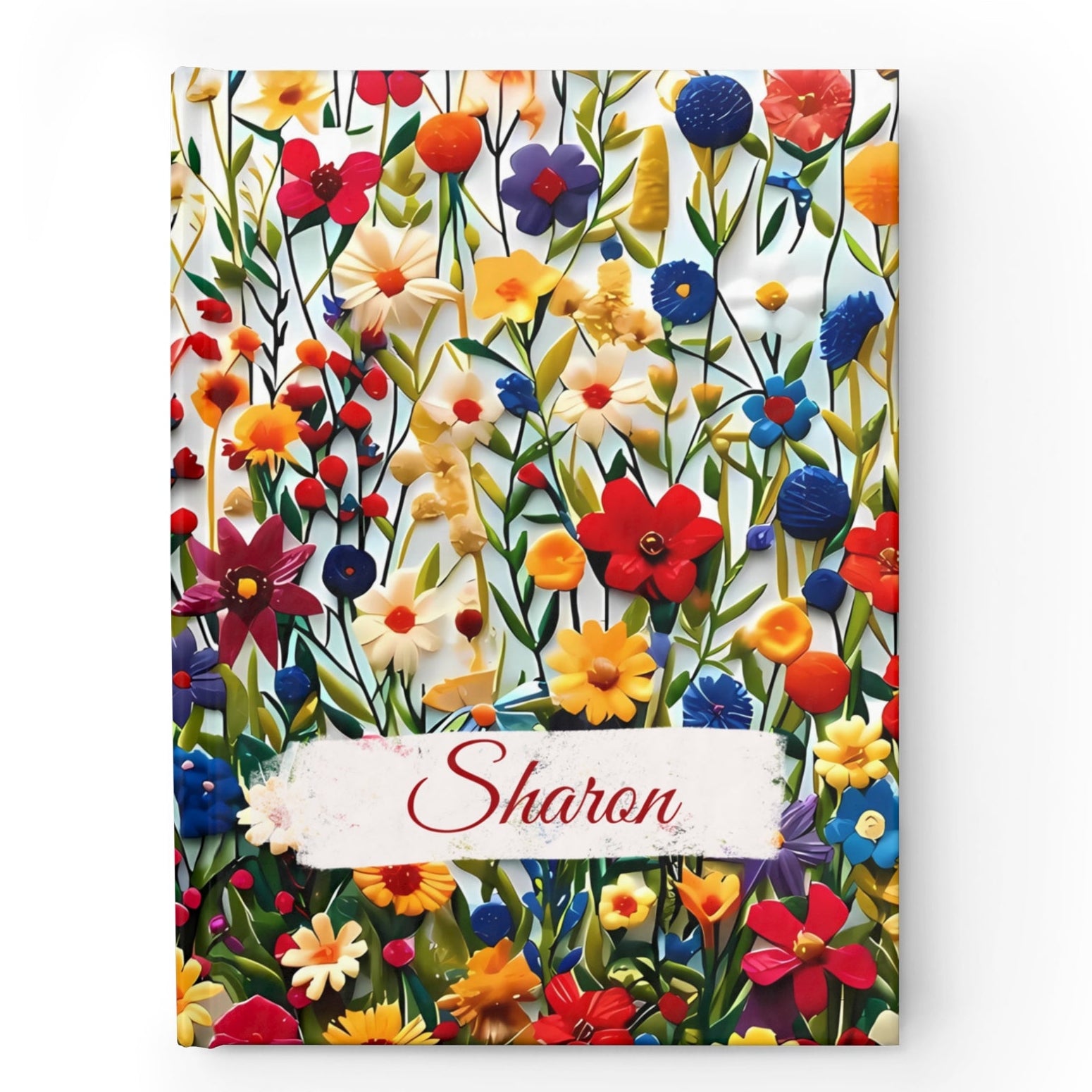 A colorful floral hardcover notebook with a variety of flowers on the cover and the name 'Sharon' printed on it.