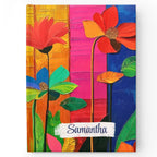 Customizable colorful flowers notebook with a hardcover and a name written on the cover, in a vertical orientation.