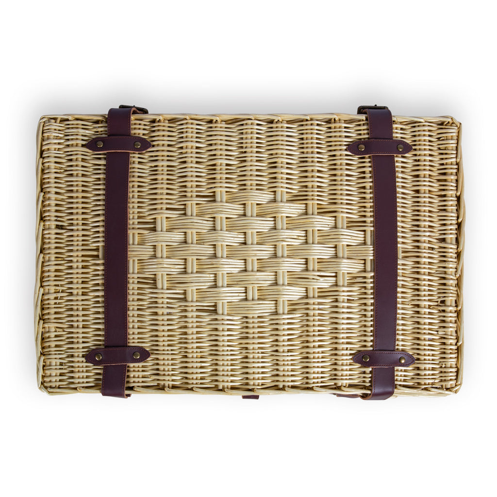Woven basket with leather straps on a white background